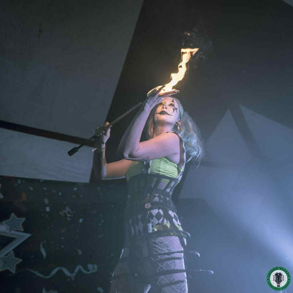 LED manipulation and fire object manipulation on stage in Virginia Beach, with Blu spinning bright props and fire tools in a choreographed circus act for concerts and corporate events.